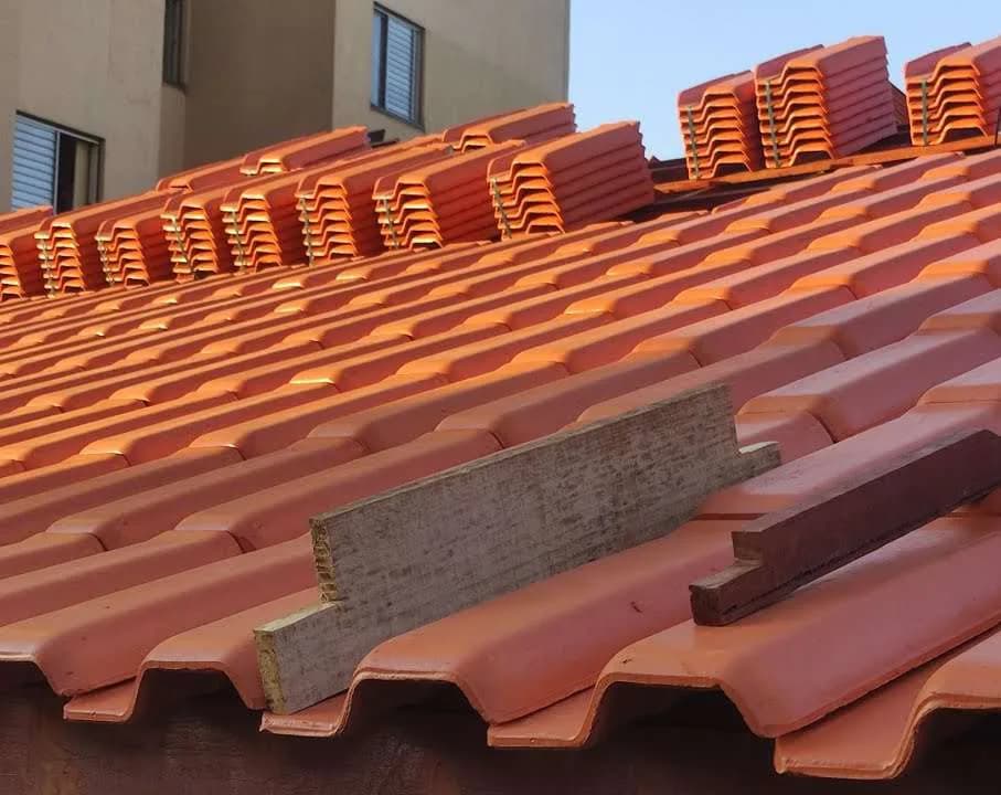 Telhas distribuídas em pilhas sobre a cobertura